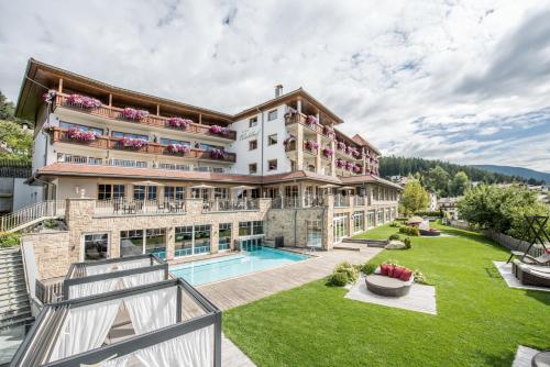 una vista exterior de un edificio con piscina en Hotel Waldhof en Perca