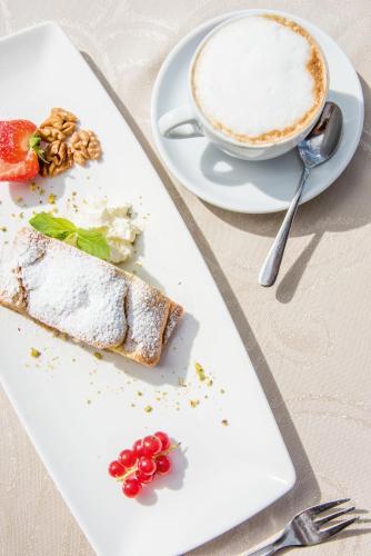a plate of food and a cup of coffee at Hotel Waldhof in Perca