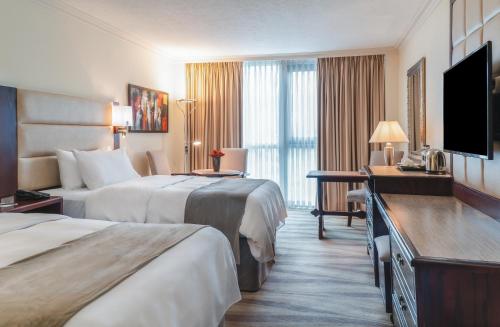a hotel room with two beds and a flat screen tv at Landmark Amman Hotel & Conference Center in Amman