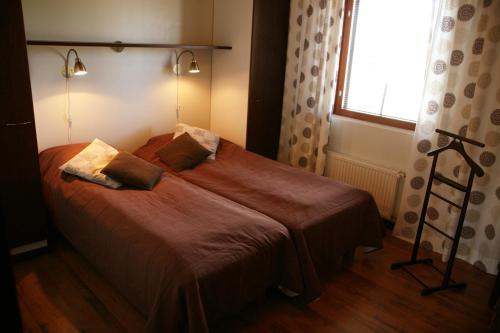 a bedroom with a bed with two pillows and a window at Apartments Anna in Tahkovuori