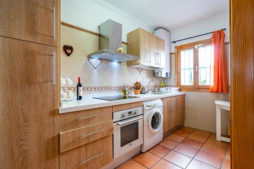 a kitchen with a sink and a washing machine at Casa Herminia in Frigiliana