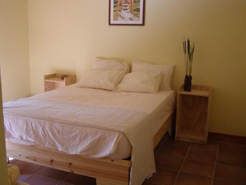 a bedroom with a bed with white sheets and pillows at Hotel Loro Tuerto in Santa Cruz de Barahona