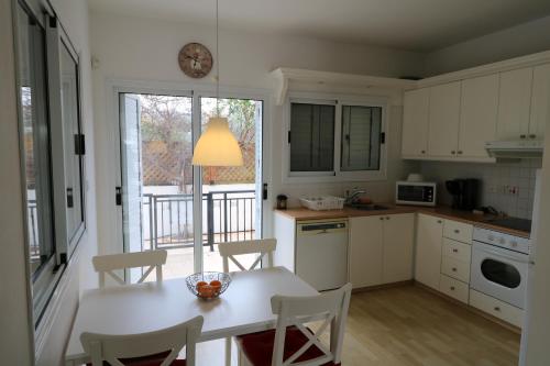 Una cocina con mesa y sillas y una ventana. en The Paradise Townhouses By Taimoura, en Pafos