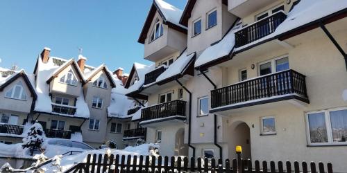 a row of houses with snow on the roofs at ComfortStudio in Zakopane