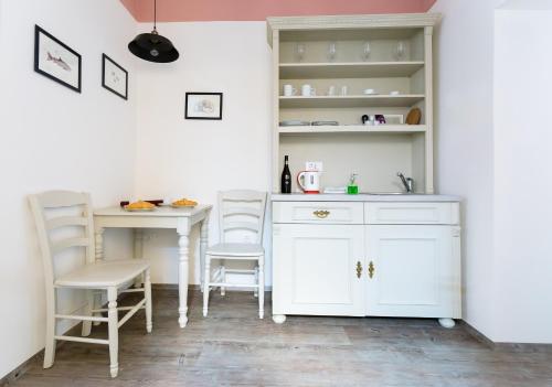 a kitchen with white cabinets and a table and chairs at Barbo Palace Apartments and Rooms in Ljubljana