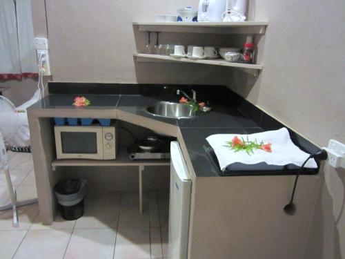 a small kitchen with a microwave and a sink at Savaii Lagoon Resort in Fagamalo
