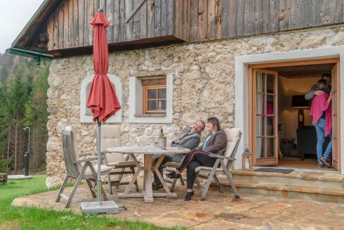 two women sitting at a table in front of a building at Obiralmhütte Mosgan in Bad Eisenkappel