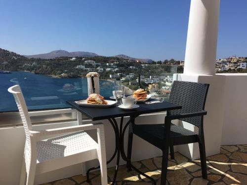 a table and chairs on a balcony with a view at Sunrise Bay in Panteli