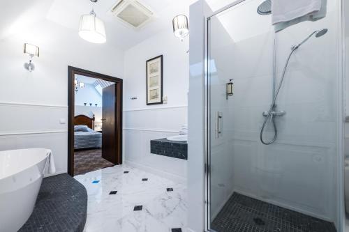 a bathroom with a shower, toilet, sink and tub at Hotel St. Bruno in Giżycko