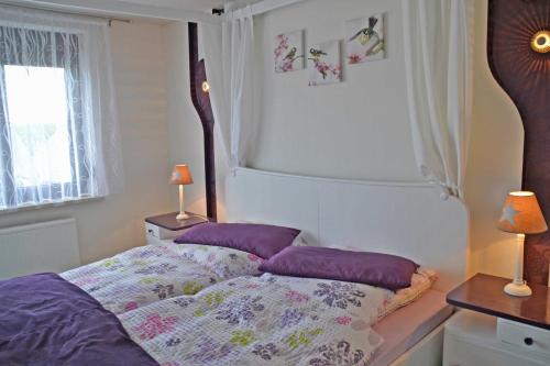 a bedroom with a bed with purple pillows on it at Ferienhaus _Hasenland_ in Kerkwitz