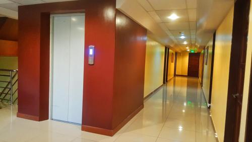 a hallway with a white door in a building at Domsowir Hotel and Restaurant in Borongan