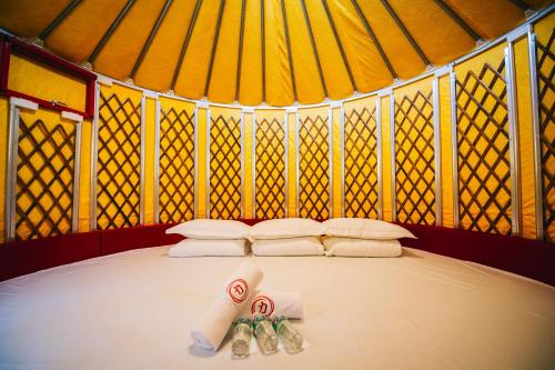 a bed in a tent with two rolled up towels at Rick Resort Teluk Intan in Teluk Intan