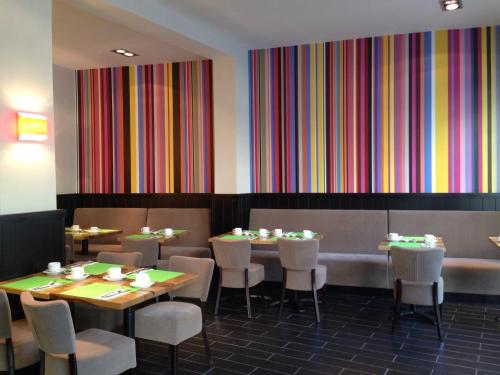 a restaurant with tables and chairs and colorful walls at Jerusalem Inn by Smart Hotels in Jerusalem