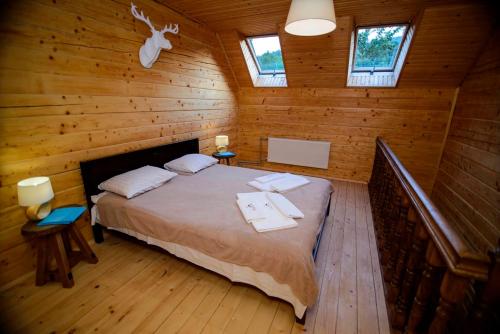 a bedroom with a bed in a wooden cabin at Shale Verba in Kvasy