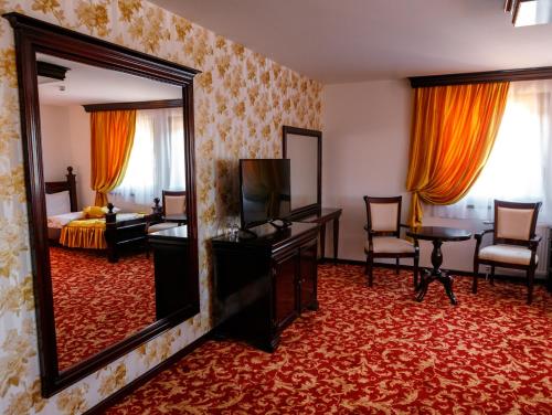 ein Hotelzimmer mit einem Spiegel und einem Schlafzimmer in der Unterkunft Hotel Zlatarski Zlatnik in Nova Varoš