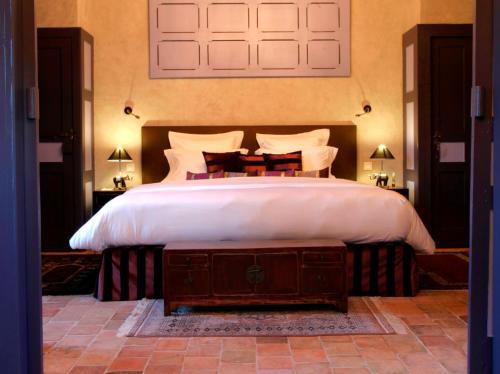 a bedroom with a large bed with white sheets and pillows at Château de l'Abbaye - Teritoria in Moreilles
