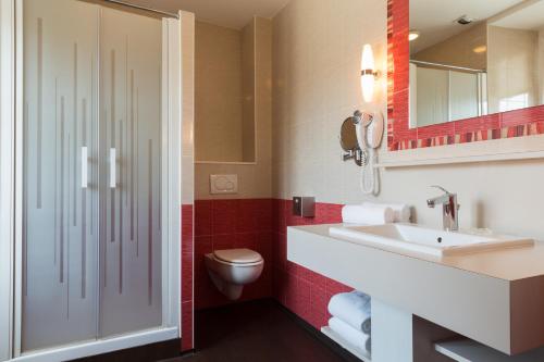 a bathroom with a sink and a toilet at Domaine Le Martinet, The Originals Relais (Relais du Silence) in Bouin