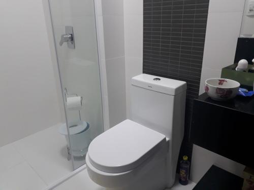 a white bathroom with a toilet and a shower at Hospedagem Domiciliar Central in Jaraguá do Sul