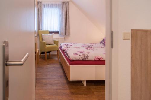 una piccola camera con letto e sedia di Ferienwohnung Am Waldrand a Dresda