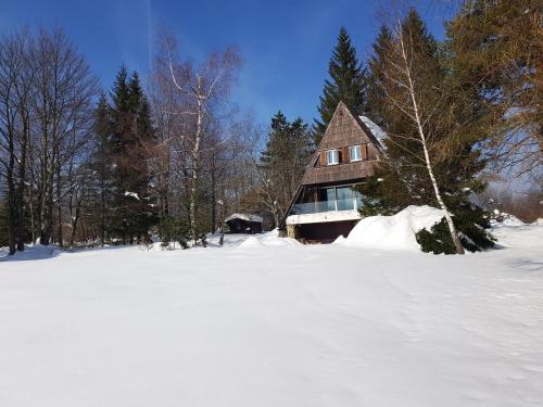 a house in a snow covered field with trees at Architect's Home Plitvice in Plitvička Jezera