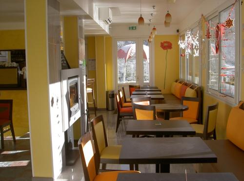 a dining room with tables and chairs and windows at Hôtel Panoramic et des Bains in Luz-Saint-Sauveur