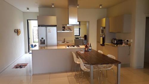 a large kitchen with a wooden table and chairs at Belle Crique B1 in Tamarin