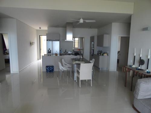 a kitchen and living room with a table and chairs at Belle Crique B1 in Tamarin