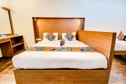 a bedroom with a large bed with a wooden headboard at FabHotel Tranquil Heights Kodaikanal in Kodaikānāl