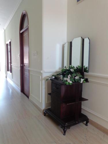 a room with a mirror and a dresser with flowers at Lakeside Inn Ratanada in Jodhpur