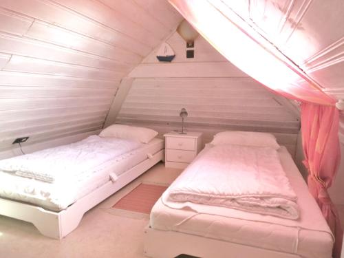two beds in a room with a attic at Huus Wattenmeer in Neßmersiel an der Nordsee in Dornum