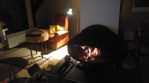 a living room with a fireplace and a chair at Architect's Home Plitvice in Plitvička Jezera