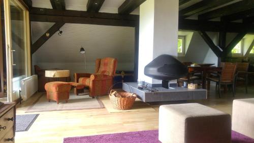 a living room with a tv and chairs and a table at Architect's Home Plitvice in Plitvička Jezera