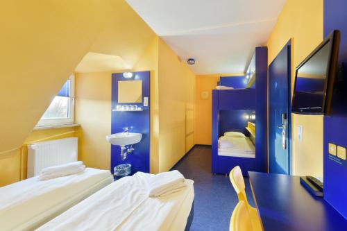 Habitación pequeña con 2 camas y lavamanos en Bed’nBudget Expo-Hostel Dorms, en Hannover