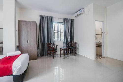 a bedroom with a bed and a table and chairs at RedDoorz @ Baloi Batam in Batam Center