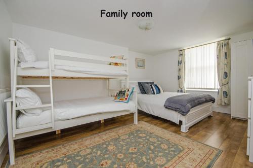 a bedroom with two bunk beds and a rug at Welsh Cosy Apartments in Llandudno