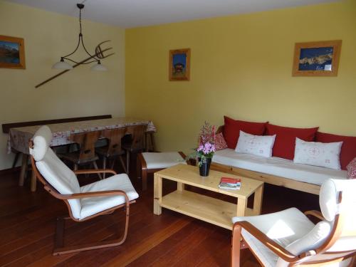 Una sala de estar con un sofá y sillas y una mesa. en Arolles 303, en Arolla