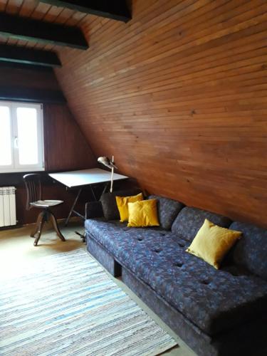 a living room with a blue couch with yellow pillows at Architect's Home Plitvice in Plitvička Jezera