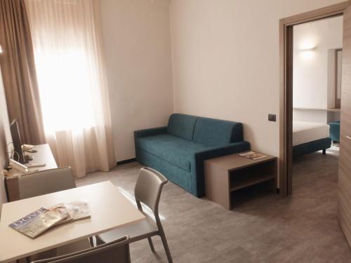 a living room with a blue couch and a table at Residence Carlton in Ferrara