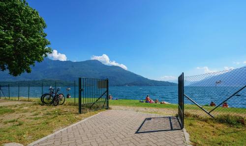a gate with a bike parked next to a body of water at bungalow campeggio madonnina in Domaso