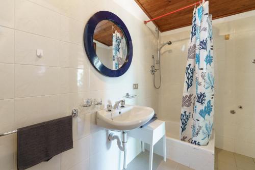 een badkamer met een wastafel, een spiegel en een douche bij bungalow campeggio madonnina in Domaso