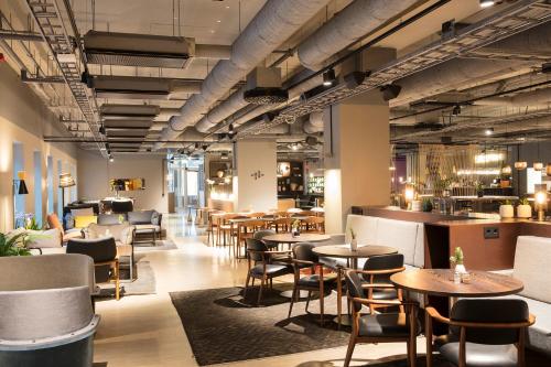 a restaurant with tables and chairs and a bar at Comfort Hotel Kista in Stockholm