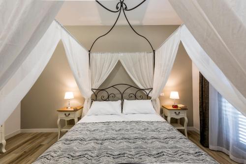 a bedroom with a canopy bed with two night stands at Il Parco dei Poeti B&B in Cellino Attanasio