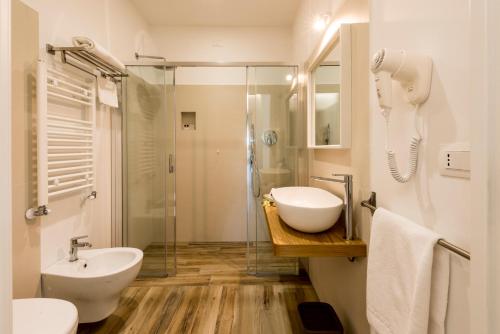 uma casa de banho com um lavatório e uma cabina de duche em vidro. em Il Parco dei Poeti B&B em Cellino Attanasio