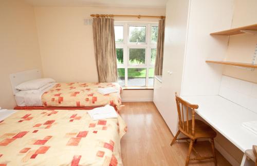 Zimmer mit 2 Betten, einem Schreibtisch und einem Fenster in der Unterkunft Courtbrack Accommodation - Off Campus Accommodation in Limerick