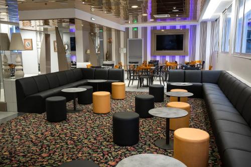 a waiting room with couches and tables and a table at Hôtel Lys de Marie in Lourdes