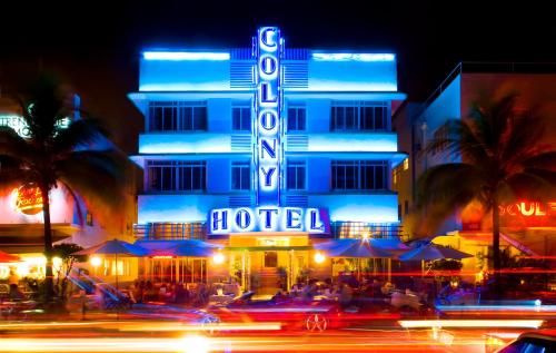 a hotel building with a neon sign at night at Colony Hotel in Miami Beach