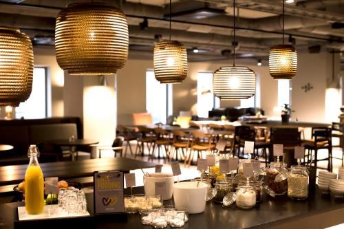 a restaurant with tables and chairs and lights at Comfort Hotel Kista in Stockholm