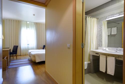 a hotel room with a sink and a bed at Hotel Santa Maria in Fátima