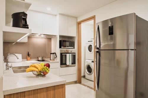 a kitchen with a bowl of fruit on a counter at Oakwood Residence Saigon in Ho Chi Minh City