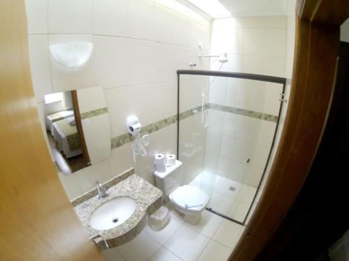 a bathroom with a sink and a toilet at Hotel Vitoria Marchi in Serra Negra